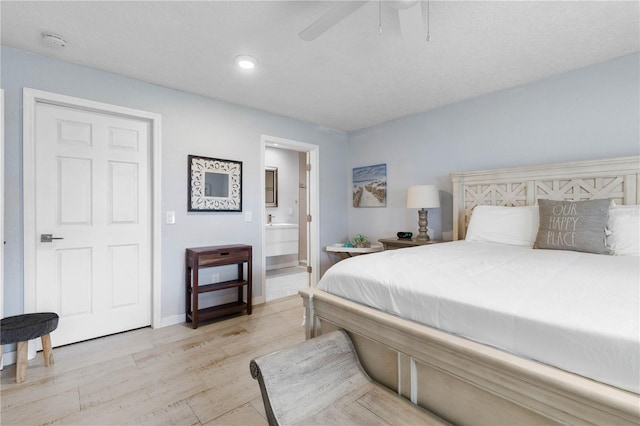 bedroom featuring ensuite bathroom, ceiling fan, and light wood-type flooring