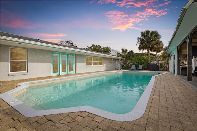 pool at dusk featuring a patio area