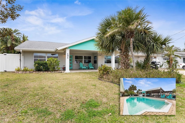 back of property featuring a lawn and a patio