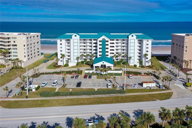 birds eye view of property with a water view and a beach view