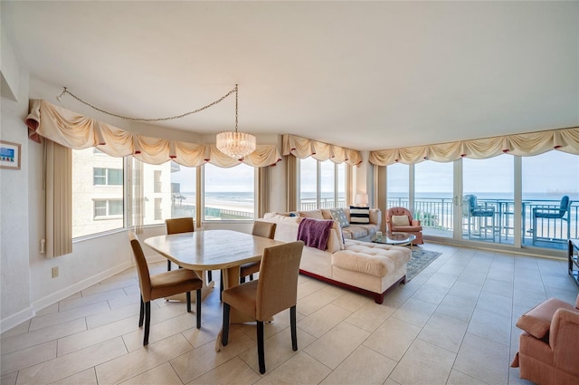 dining space featuring a chandelier, light tile patterned floors, and a water view