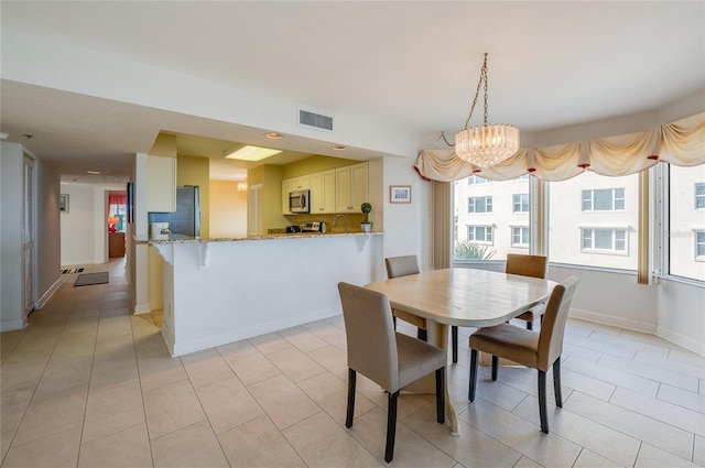 dining area with light tile patterned floors and a chandelier