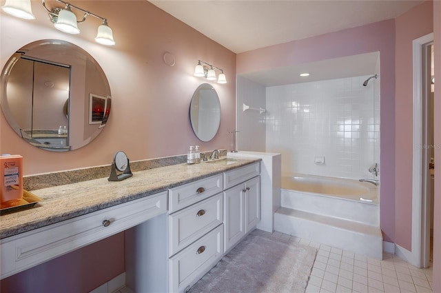 bathroom with tile patterned flooring, tiled shower / bath, and vanity