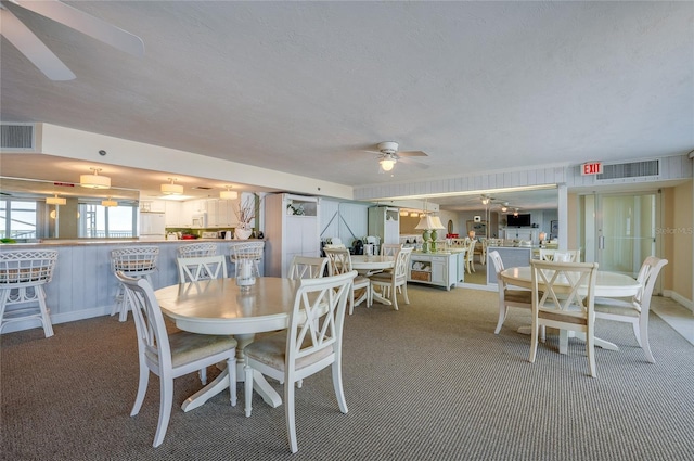 carpeted dining area featuring ceiling fan