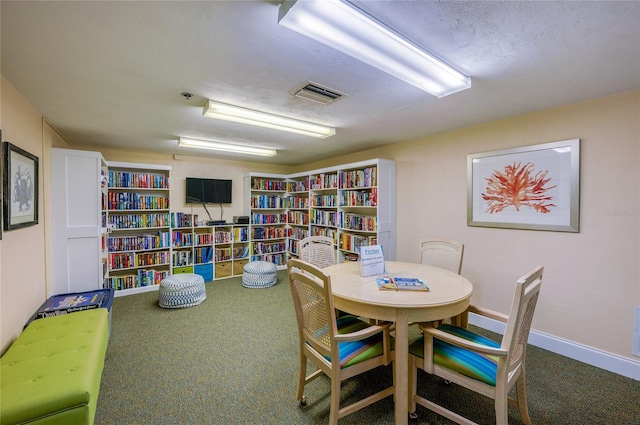 interior space with a textured ceiling and carpet flooring