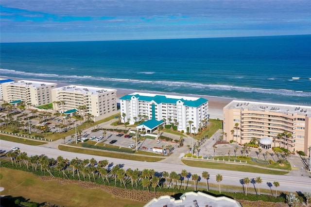 drone / aerial view featuring a water view and a view of the beach