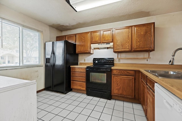 kitchen featuring light tile patterned flooring, sink, and black appliances