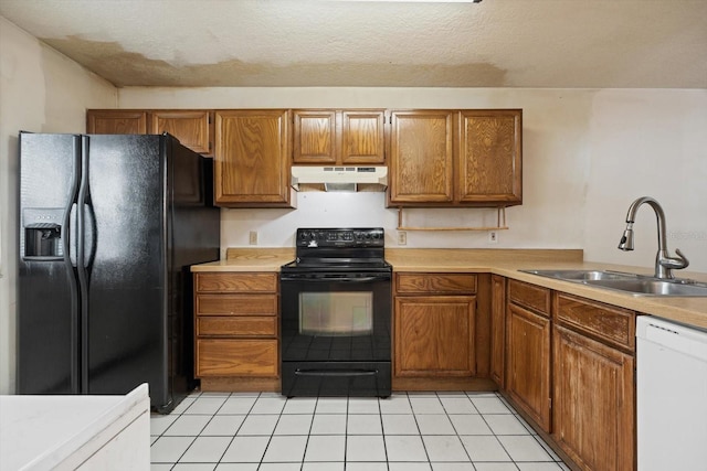 kitchen with a textured ceiling, light tile patterned floors, sink, and black appliances