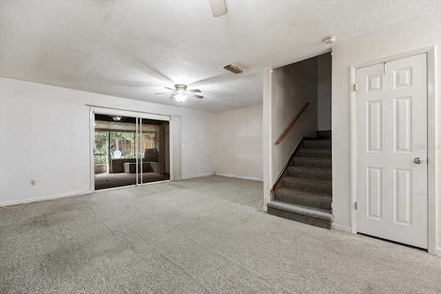 unfurnished living room with a textured ceiling, ceiling fan, and light colored carpet