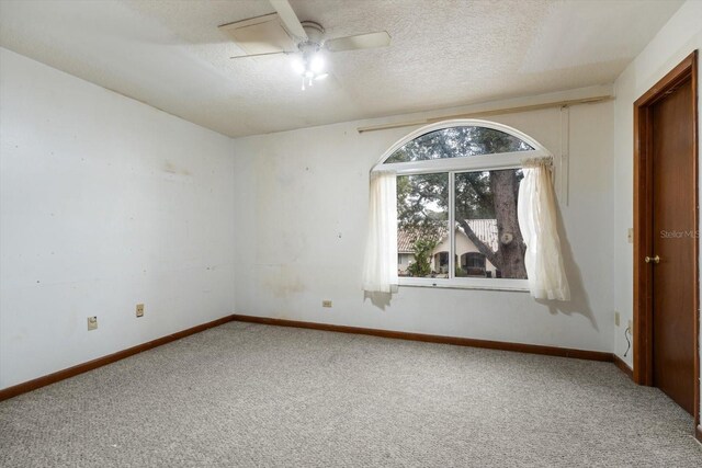 spare room featuring ceiling fan, carpet, and a textured ceiling