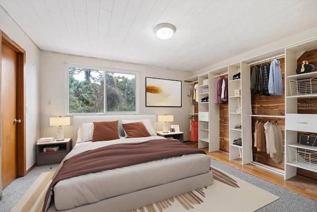 bedroom with light wood-type flooring, a closet, and wooden ceiling