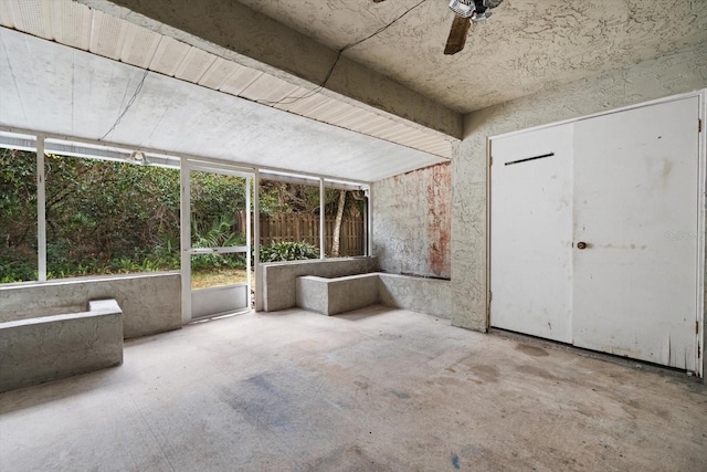 unfurnished sunroom with ceiling fan