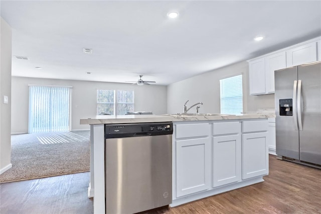 kitchen with stainless steel appliances, sink, wood-type flooring, and white cabinets