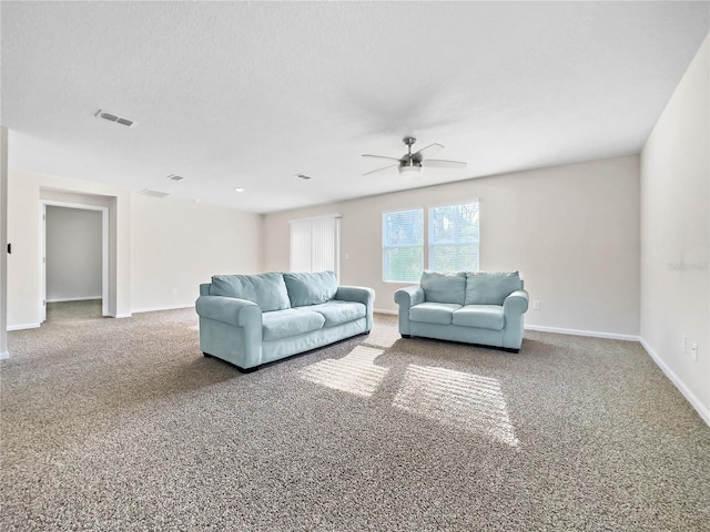 living room featuring ceiling fan, carpet, and a textured ceiling