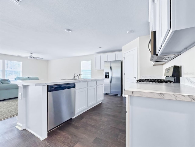 kitchen featuring appliances with stainless steel finishes, a wealth of natural light, sink, and white cabinets