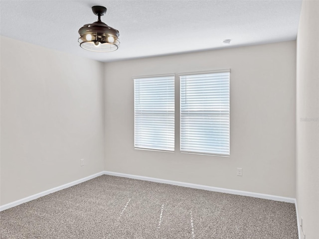 empty room featuring a textured ceiling and carpet