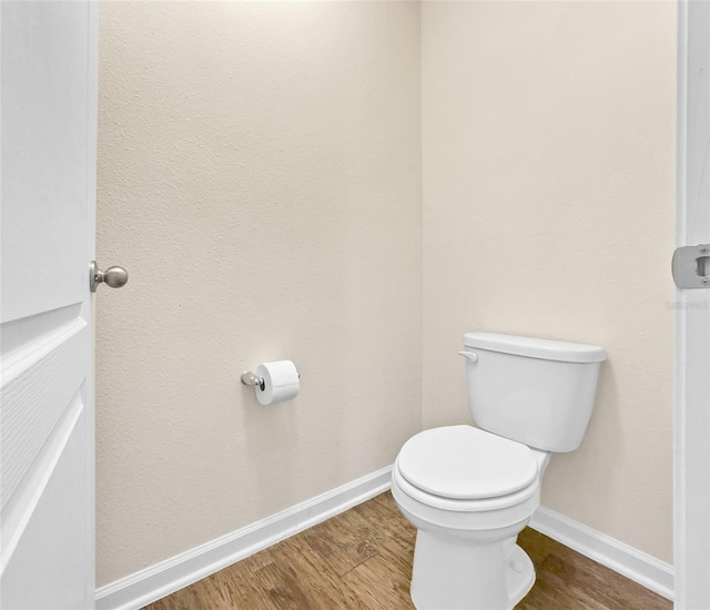 bathroom with hardwood / wood-style flooring and toilet