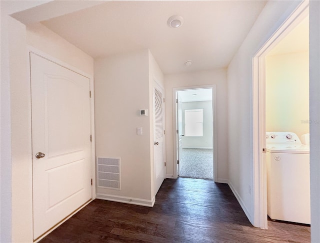 hallway featuring washer / clothes dryer and dark hardwood / wood-style flooring