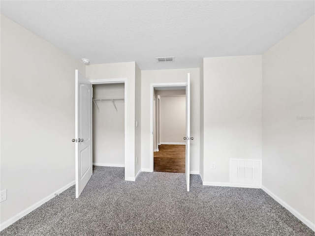 unfurnished bedroom featuring carpet floors, a textured ceiling, and a closet