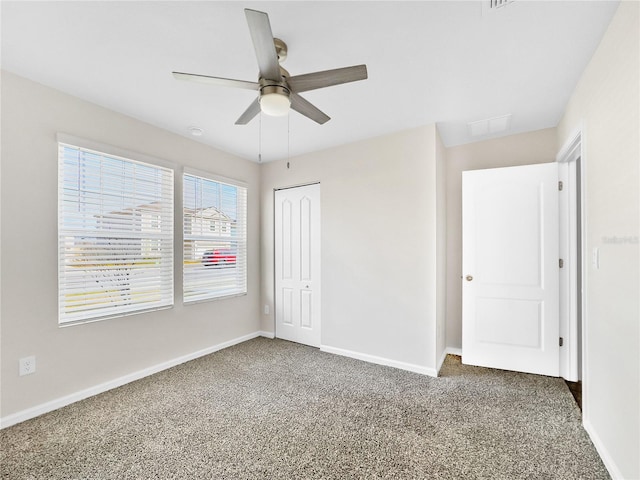 unfurnished bedroom featuring dark carpet, a closet, and ceiling fan