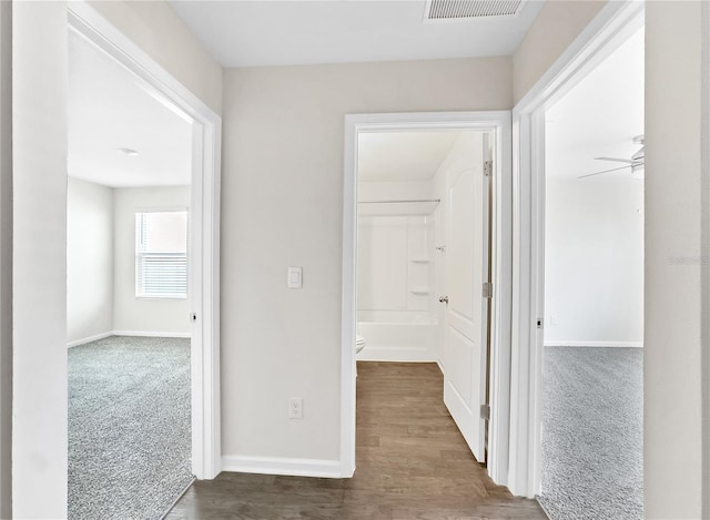 hallway featuring dark colored carpet