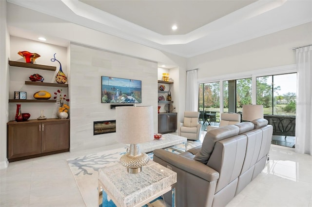 living room with a tile fireplace, light tile patterned floors, built in features, and a tray ceiling