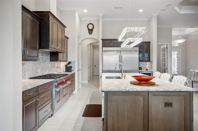 kitchen with sink, a breakfast bar area, an island with sink, and high quality appliances