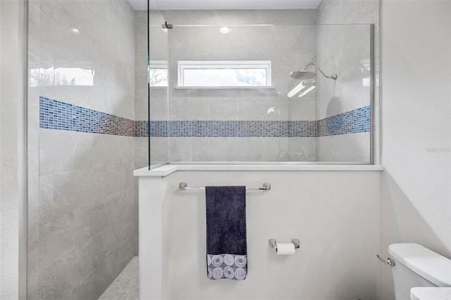 bathroom featuring toilet and tiled shower