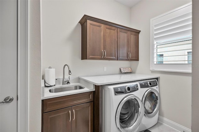 washroom featuring sink, washer and clothes dryer, and cabinets