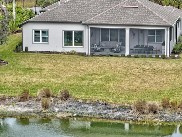 back of property featuring a water view, a patio area, a sunroom, and a lawn