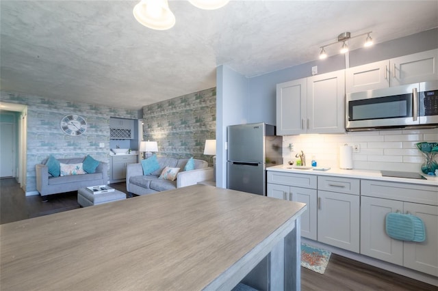 kitchen with stainless steel appliances, dark hardwood / wood-style flooring, and tasteful backsplash