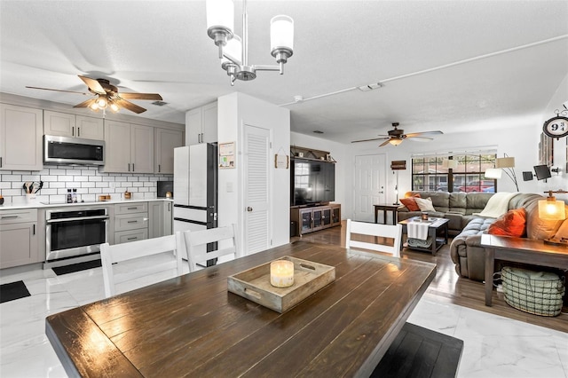 interior space featuring ceiling fan with notable chandelier and a textured ceiling