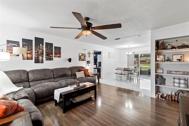 living room featuring a textured ceiling, dark hardwood / wood-style flooring, and ceiling fan with notable chandelier