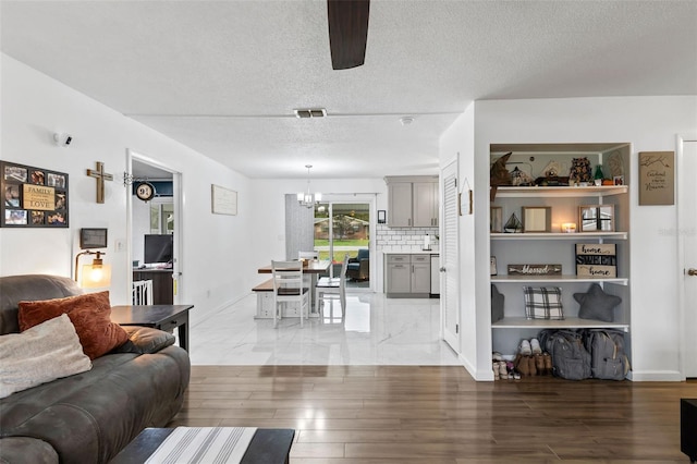 living room featuring a textured ceiling, ceiling fan, and hardwood / wood-style floors