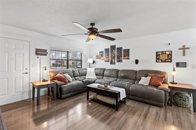 living room with wood-type flooring, a textured ceiling, and ceiling fan