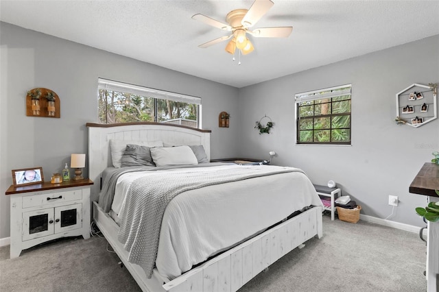 carpeted bedroom featuring a textured ceiling and ceiling fan