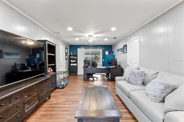 living room featuring ceiling fan, crown molding, and light hardwood / wood-style flooring