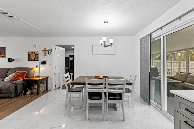 dining room featuring a textured ceiling and a notable chandelier