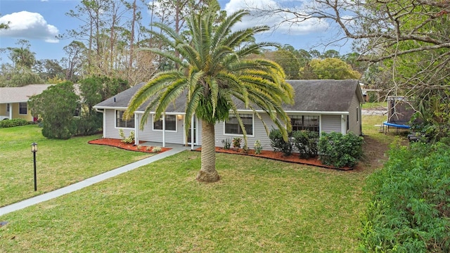 single story home featuring a front yard and a trampoline