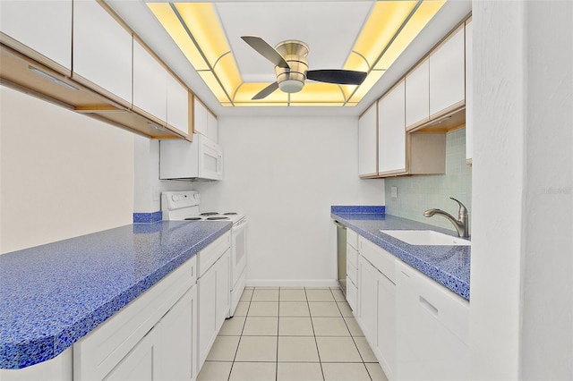 kitchen featuring white cabinetry, sink, ceiling fan, a tray ceiling, and white appliances