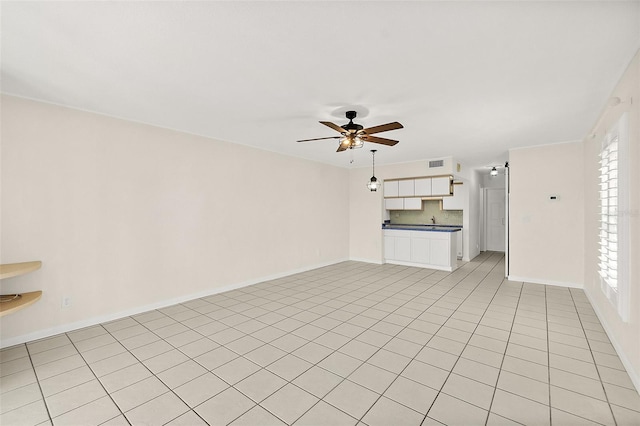 unfurnished living room featuring light tile patterned floors and ceiling fan