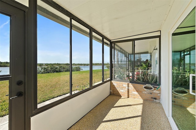 sunroom / solarium featuring a water view