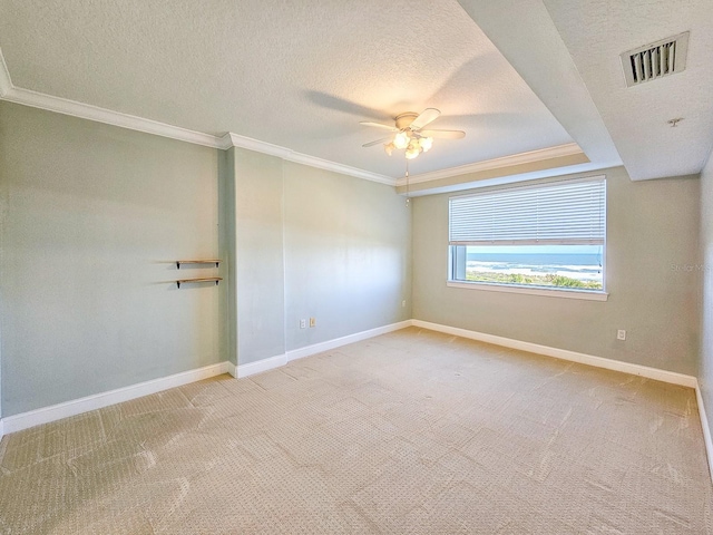 unfurnished room featuring ceiling fan, ornamental molding, light colored carpet, and a textured ceiling