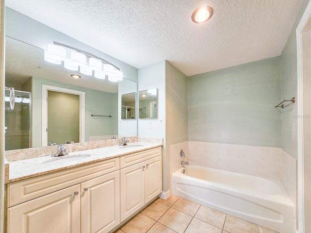 bathroom featuring tile patterned flooring, vanity, shower with separate bathtub, and a textured ceiling