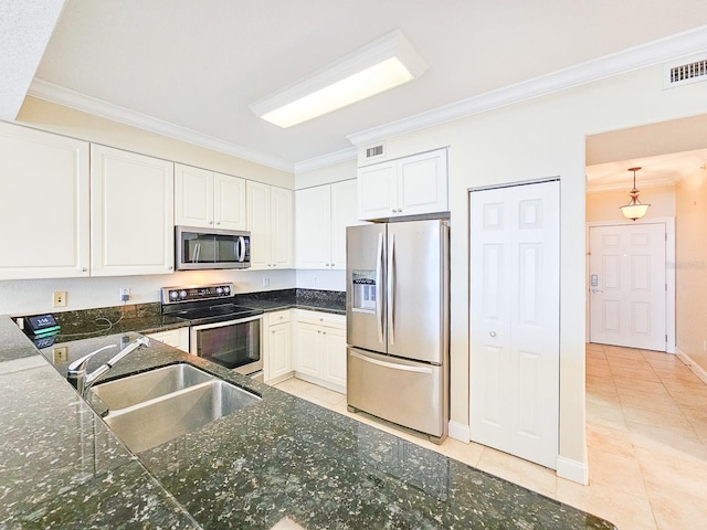 kitchen with appliances with stainless steel finishes, sink, light tile patterned floors, and white cabinets