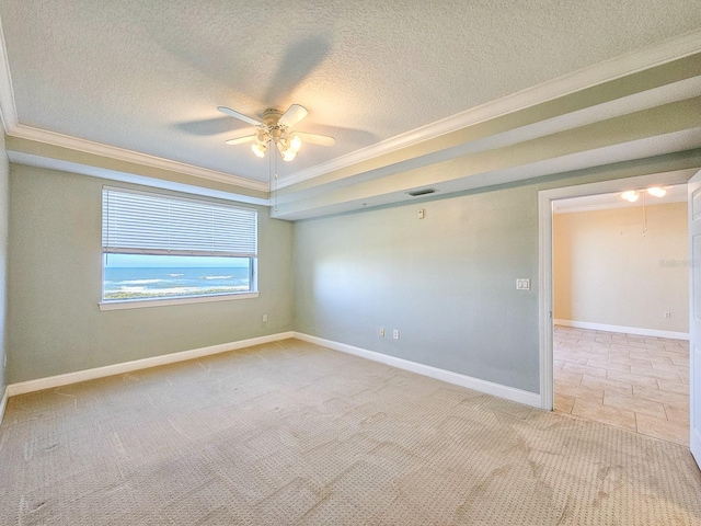 spare room with light carpet, a textured ceiling, ornamental molding, and ceiling fan