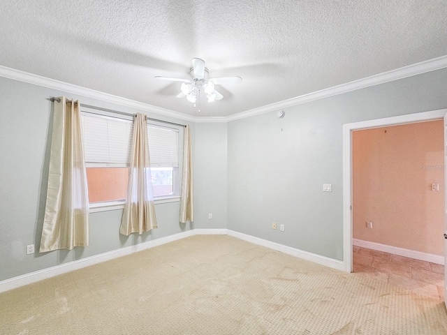 empty room featuring crown molding, carpet flooring, and ceiling fan