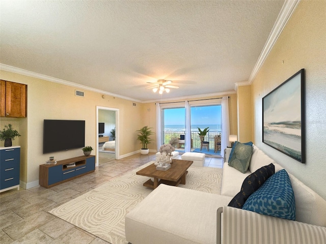 living room featuring ceiling fan, ornamental molding, and a textured ceiling