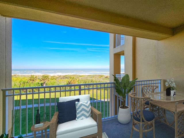 balcony featuring a water view and a beach view