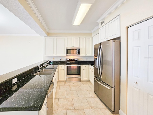 kitchen featuring sink, white cabinetry, dark stone countertops, stainless steel appliances, and light tile patterned flooring